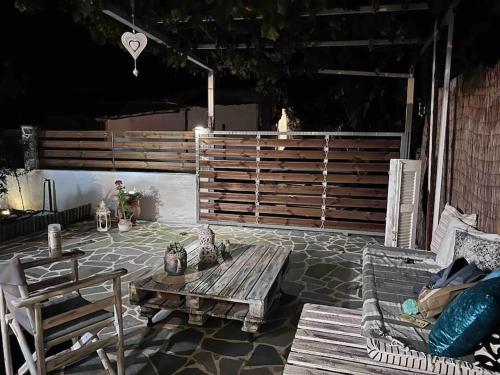 un patio con una mesa de madera y 2 sillas en Ευχάριστο εξοχικό σπίτι!, en AgiaKampos