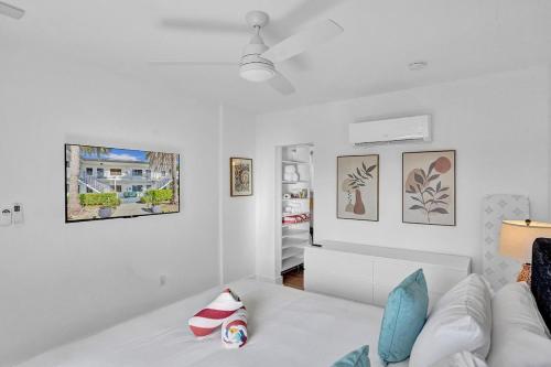 a white living room with a white couch and pictures on the wall at Waves On Walnut - Beach Access in Hollywood