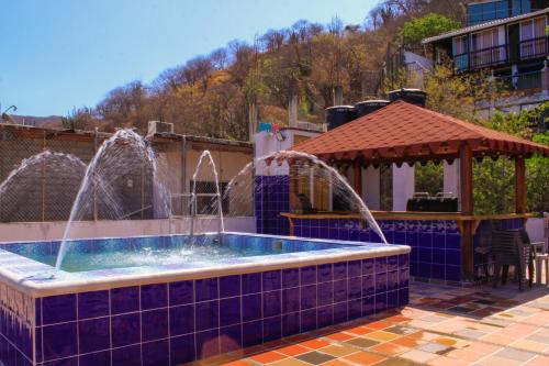 een zwembad met fonteinen en een prieel bij Casa Arev in Taganga