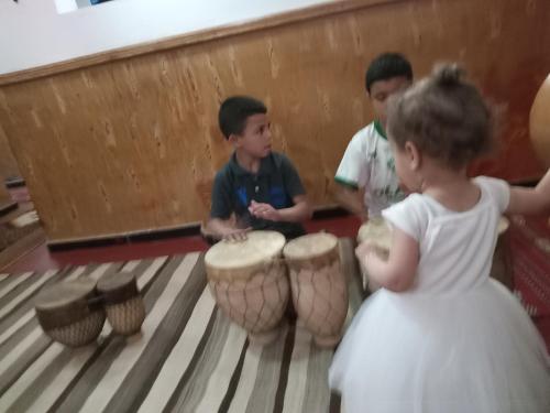 a little girl and two boys playing drums at Auberge NICE VIEW DADES in Akhendachou nʼAït Ouffi