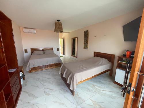 a bedroom with two beds and a tiled floor at De Olho no Mar A única pousada de frente para o mar em Paracuru in Paracuru