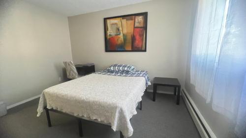 a bedroom with a bed and a painting on the wall at Private Room in Oliver 104 ave, Across Grand McEwan University, Norquest College, A Chic Location! in Edmonton