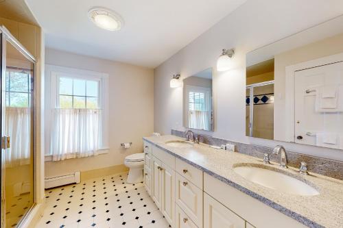 a bathroom with two sinks and a toilet at Miller Creek Cove Retreat in Brunswick