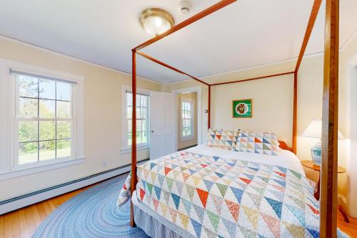 een slaapkamer met een bed en 2 ramen bij Miller Creek Cove Retreat in Brunswick