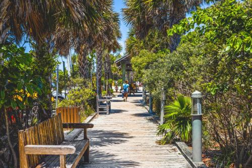 a person riding a bike down a path with benches at Longboard in Holmes Beach