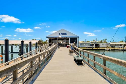 a boardwalk leading to a marina with a mro building at Longboard in Holmes Beach