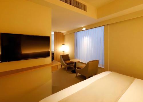 a hotel room with a bed and a tv and a table at THE GENERAL KYOTO Bukkouji Shinmachi in Kyoto