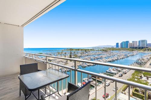 a balcony with a table and a view of a marina at Marina Views Studio - Ilikai, 941 in Honolulu