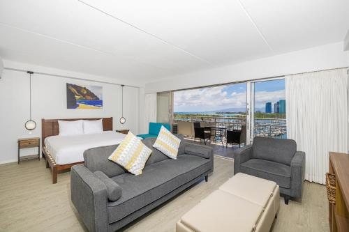 a bedroom with a bed and a couch and a bed at Marina Views Studio - Ilikai, 941 in Honolulu