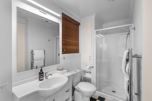 Baño blanco con lavabo y aseo en Village Apartment Havelock North, en Havelock North