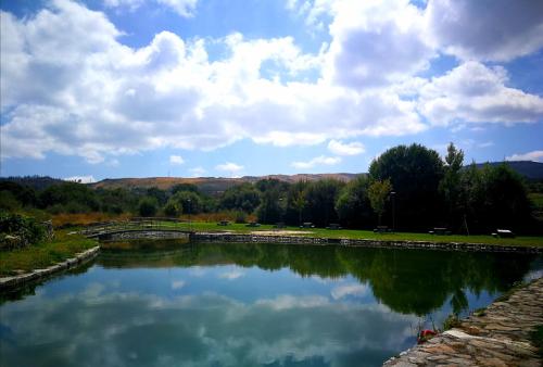 a river with a bridge and clouds in the sky at AL - Casa dos Alentejanos in Carregal