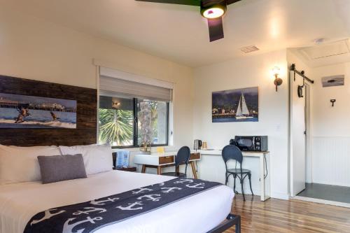 a bedroom with a bed and a desk and a kitchen at Haley Hotel in Santa Barbara