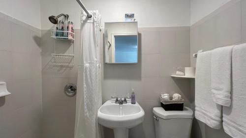 Baño blanco con lavabo y aseo en Cozy Rooms, en Homestead