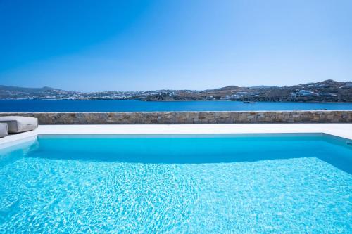 a swimming pool with a view of the water at Myko Villa by Bestofmikonos in Ornos