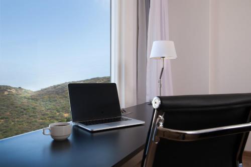 a laptop computer sitting on a desk next to a window at Fiesta Inn Tuxtla Fashion Mall in Tuxtla Gutiérrez