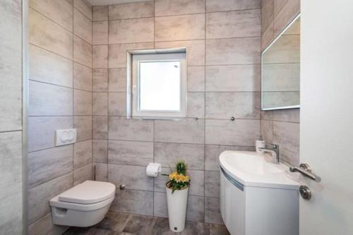 La salle de bains est pourvue de toilettes, d'un lavabo et d'une fenêtre. dans l'établissement Holiday House "Jere & Leon" - Villa With Sea View, à Ljubač