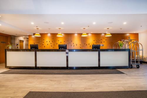 a lobby with a reception desk in a building at Sandman Hotel Hamilton in Hamilton