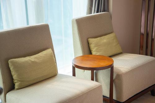 a living room with a chair and a table at Junluxe Hotel Guangzhou Science City-Free Shuttle Bus Service to Guangzhou Canton Fair in Guangzhou