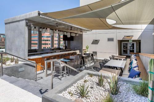 a rooftop patio with a bar and tables and chairs at Omni Tempe Hotel at ASU in Tempe
