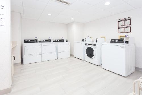 a laundry room with white washers and dryers at Holiday Inn Express & Suites Williamsburg by IHG in Williamsburg