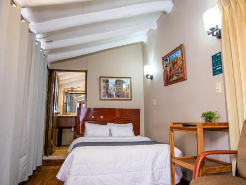 a hotel room with a bed and a chair at Hotel Guest House Wayra in Cusco