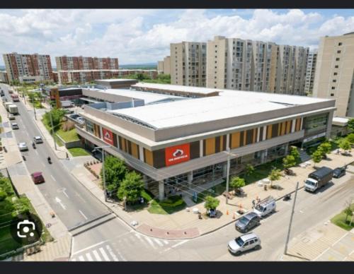 un grand bâtiment dans une rue de la ville avec un parking dans l'établissement Confortable Apartamento, à Barranquilla