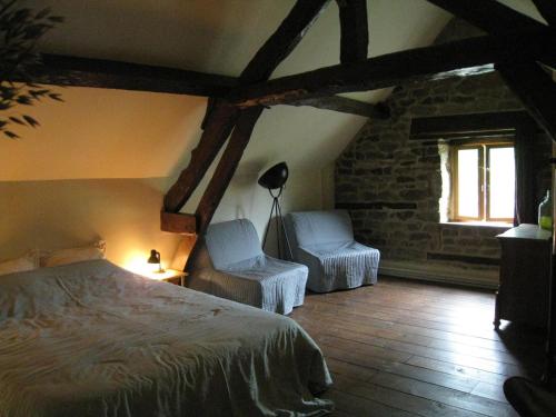 a bedroom with two chairs and a bed and a window at Cozy Holiday Home in Ceauc in Céaucé