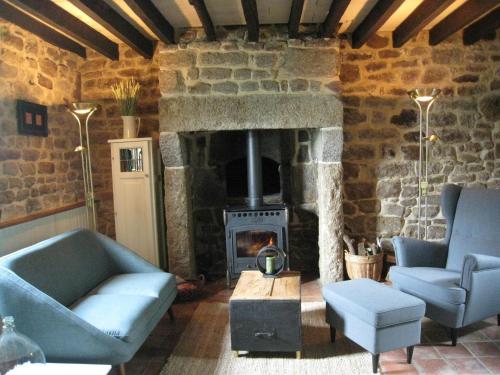 a living room with two blue couches and a fireplace at Cozy Holiday Home in Ceauc in Céaucé