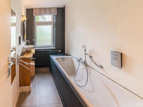 bagno con vasca e lavandino di Luxurious holiday home on the banks of the Ourthe a Barvaux-sur-Ourthe