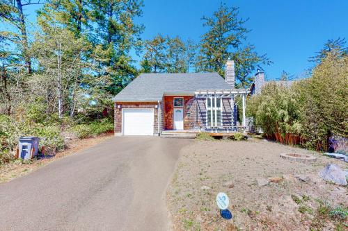 a house with a garage on a dirt road at Castaway Cabin in Manzanita