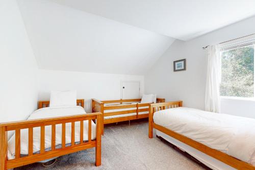 a bedroom with two beds and a window at Castaway Cabin in Manzanita
