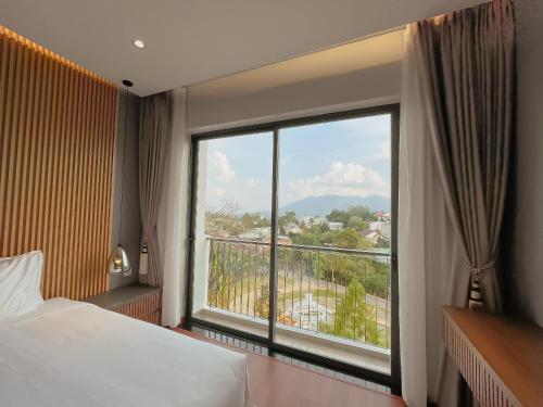 1 dormitorio con ventana grande con vistas en Sunflower Hotel & Resort, en Bao Loc