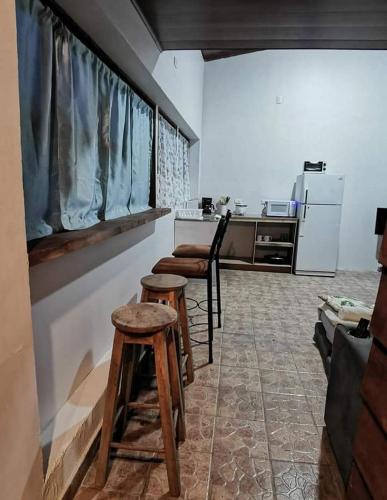 a room with two stools and a kitchen with a counter at Cabaña Bambú in Cartago