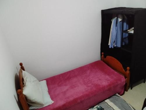 a small bench with a red blanket and a cabinet at Chambre privée dans une appartement calme 