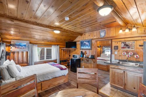 a bedroom with a bed and a kitchen in a cabin at The Bucking Moose in West Yellowstone