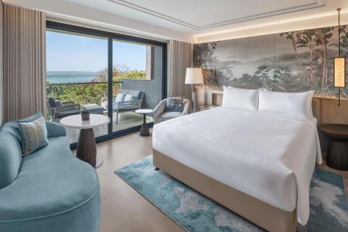 a bedroom with a large bed and a living room at JW Marriott Goa in Vagator