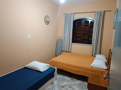 Habitación pequeña con 2 camas y ventana en Casa OliMar fins de semana, en Bertioga
