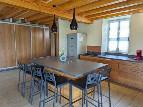 a kitchen with a large wooden table and chairs at Gîte Charentais avec piscine, terrasse, et pêche - confort moderne et charme rural - FR-1-653-87 in Salles-de-Barbezieux