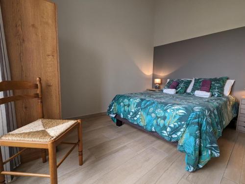 a bedroom with a bed and a chair at Gîte Charentais avec piscine, terrasse, et pêche - confort moderne et charme rural - FR-1-653-87 in Salles-de-Barbezieux