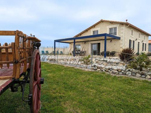 a house with a tractor in front of it at Gîte Charentais avec piscine, terrasse, et pêche - confort moderne et charme rural - FR-1-653-87 in Salles-de-Barbezieux