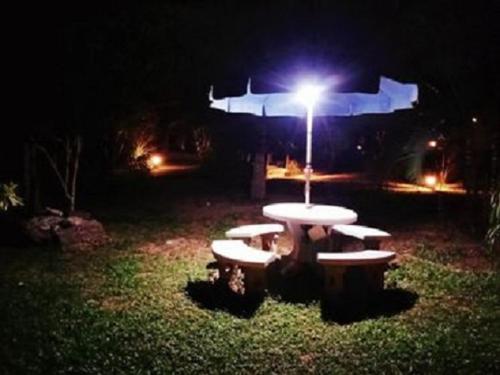 a picnic table in a park at night with a light at Najjamee Bungalows in Ko Yao Noi