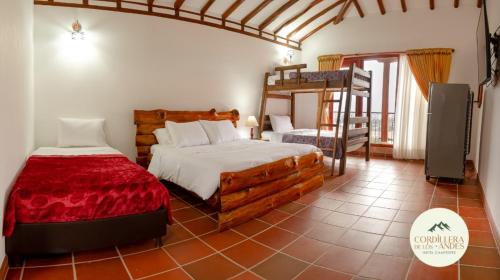 a bedroom with two beds and a bunk bed at Hotel Campestre Cordillera de los Andes in Villa de Leyva