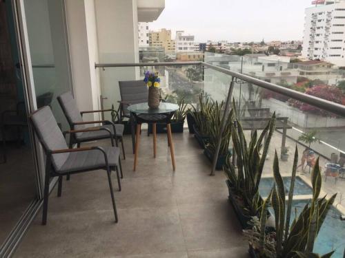 a balcony with a table and chairs and plants at Dep. Salinas, Chipipe. in Salinas