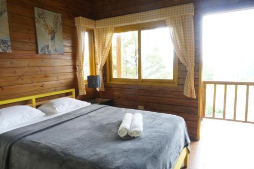 a bedroom with a bed with two towels on it at The Woods By Celebration in Jarabacoa