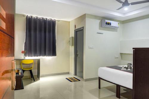 a hospital room with a bed and a yellow chair at Collection O White Riviera Near Kondapur in Hyderabad