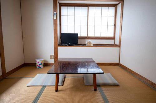 a small room with a table in front of a window at Mansyuya in Isozaki