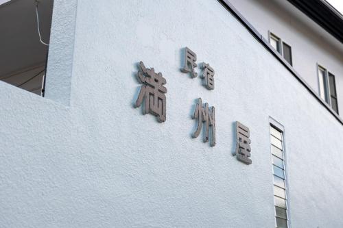 a white building with signs on the side of it at Mansyuya in Isozaki