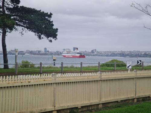 a large boat in the water with a fence at Waterfront Quiet Stay off Geelong & Avalon Airport in North Shore
