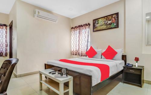 a hotel room with a bed with red pillows at Hotel Airport Shine Inn in Shamshabad