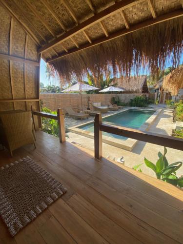 an open deck with a view of a swimming pool at My Island Home Gili Air in Gili Islands